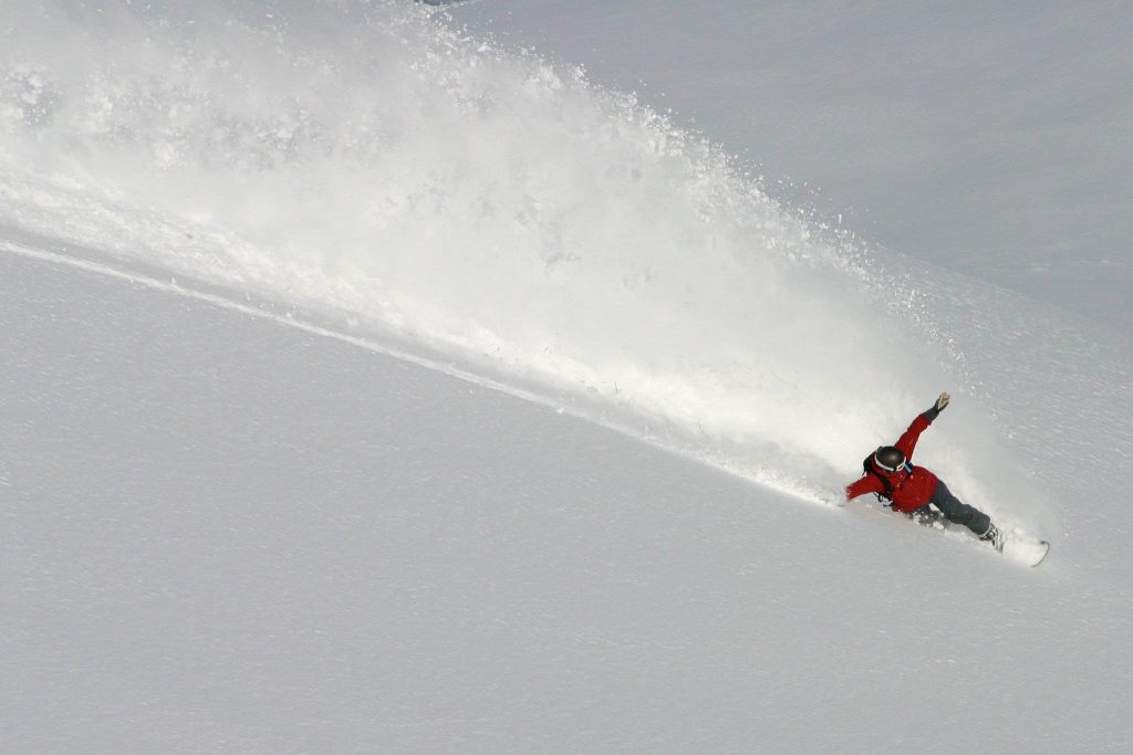 Heli skiing - snowboarder in powder