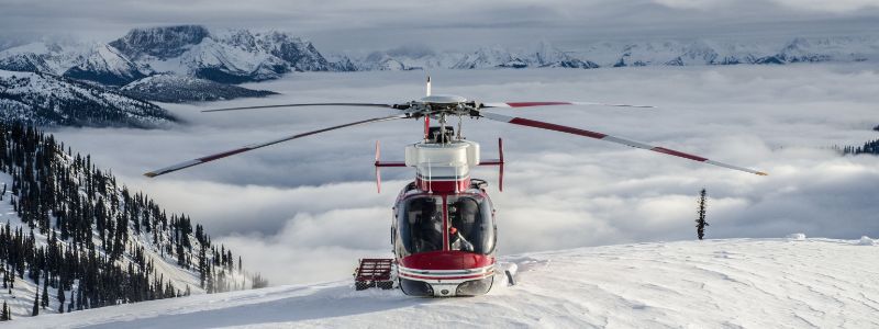 Helicopter-skiing-helicopter-waiting-on-slopes-min