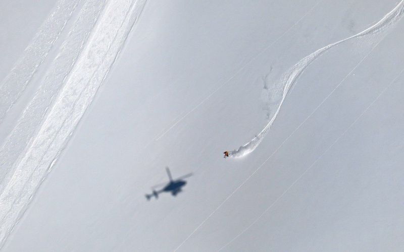 heli-skiing-backcountry-skiing-with-helicopter's-shadow-on-the-snow-min