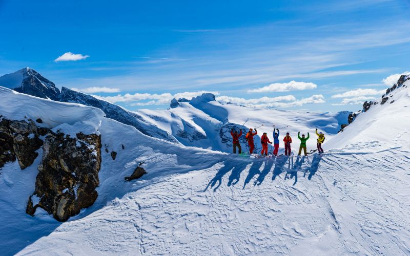 heli-skiing-group-of-skiers-ready-for-their-run-down-the-slope-min