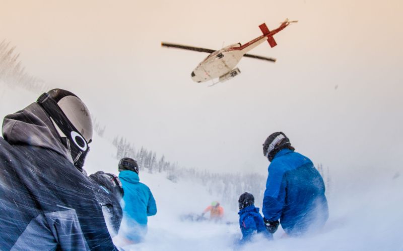heli-skiing-helicopter-dropping-off-a-group-of-skiers-min