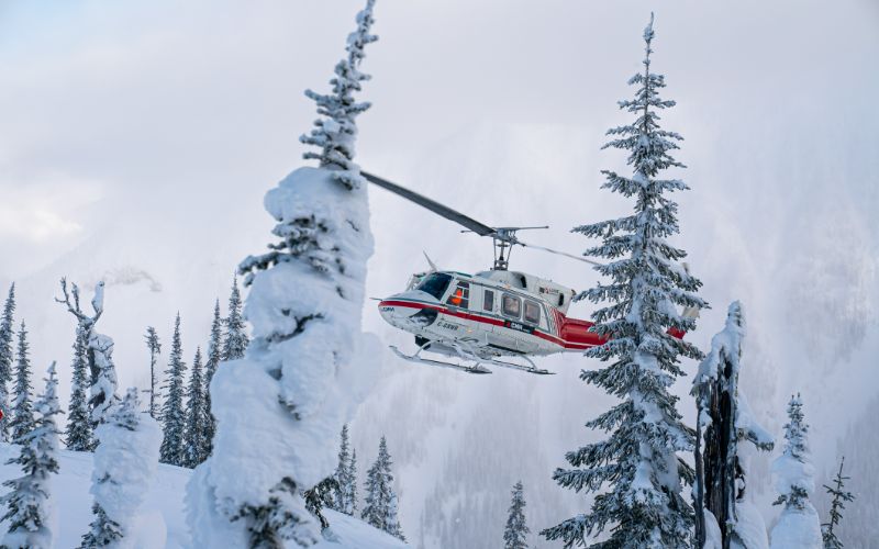 heli-skiing-helicopter-over-snowy-forest-min
