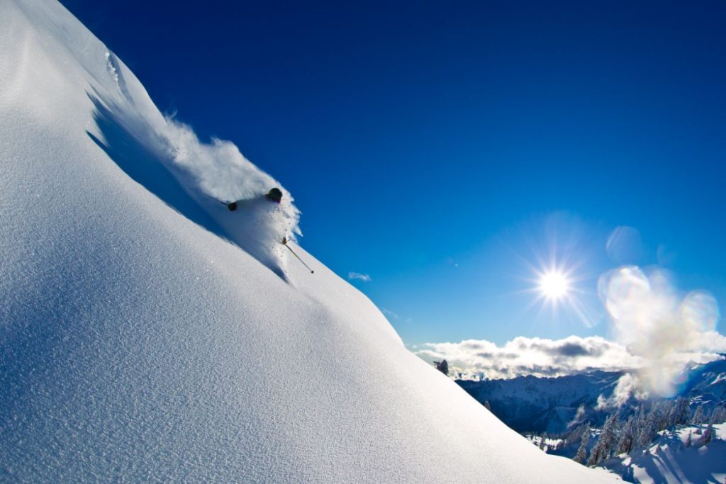 heli-skiing-man-skiing-down-powder-slope-min