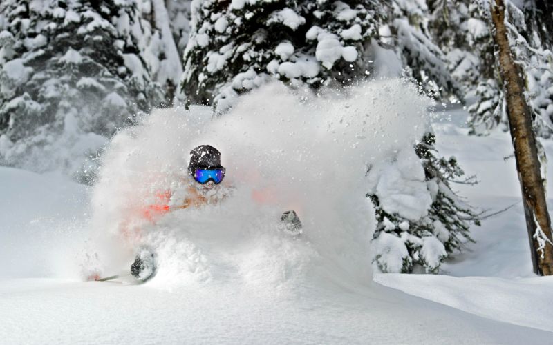 off-piste-skiing-close-up-of-skier-carving-through-powder-snow-min