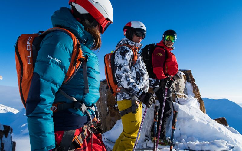 heli-ski-group-of-skiers-posing-for-photo-min