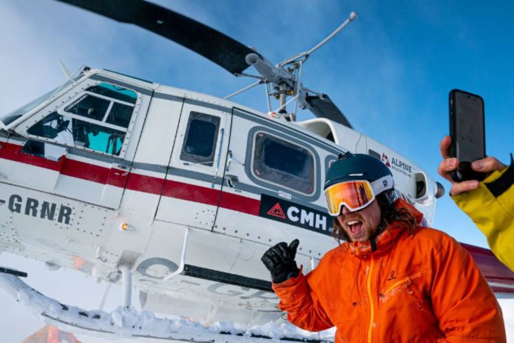 heli-ski-skiers-disembarking-and-posing-in-front-of-helicopter-min