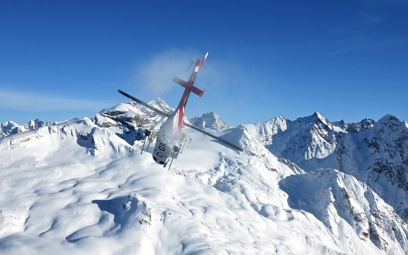 helicopter-skiing-helicopter-flying-over-mountain-range-min