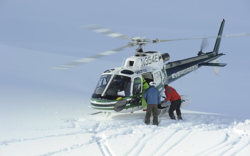 heli-skiing-helicopter-dropping-people-on-slope (1)-min