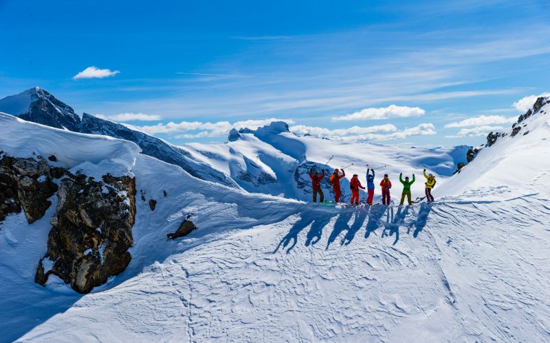 helicopter-skiing-group-of-skiers-posing-for-photo-min