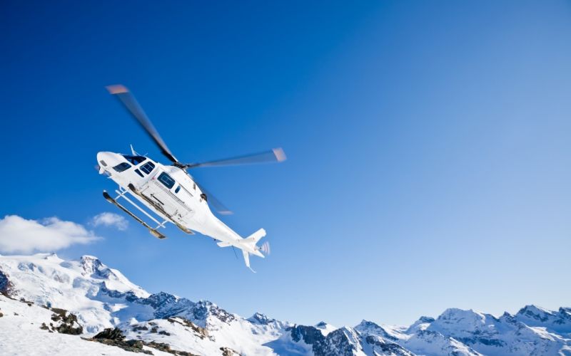helicopter-skiing-flying-above-mountain-min