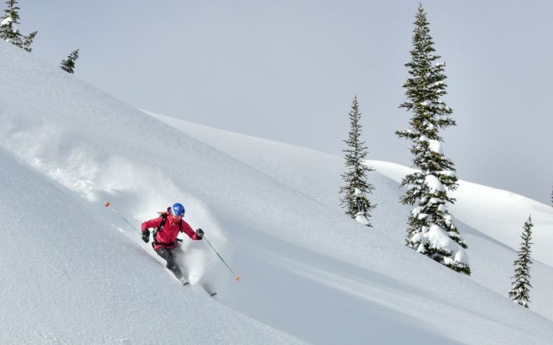 affordable-heli-skiing-skiing-down-mountain-min