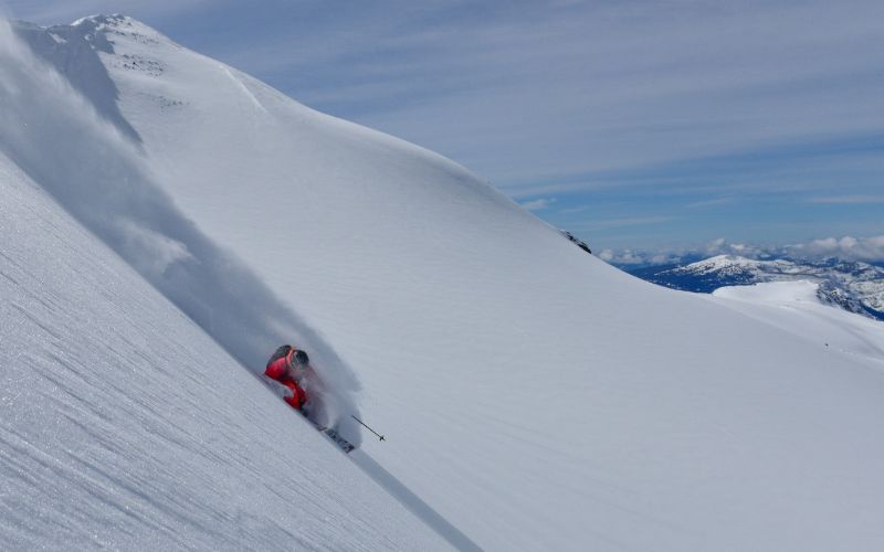 heliskiing-canada-prices-skiing-down-mountain-min