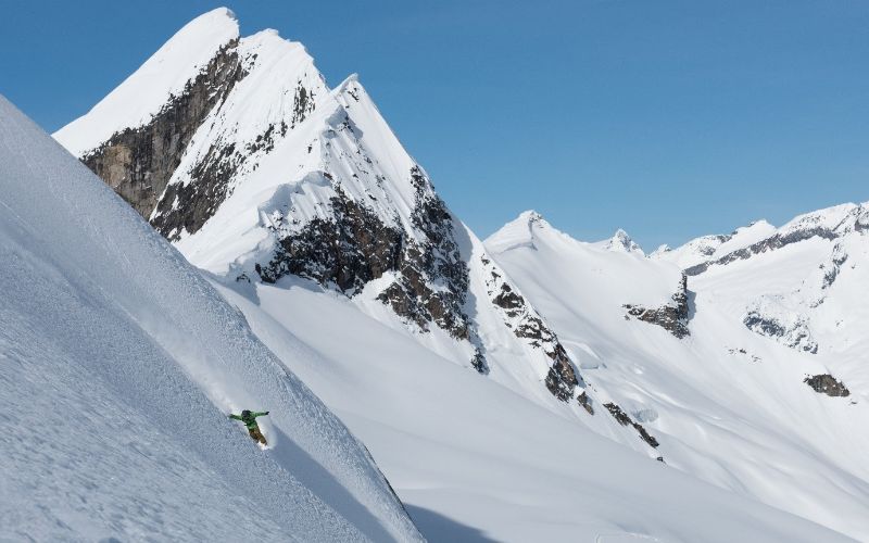 affordable-heli-skiing-skiing-down-mountain-min